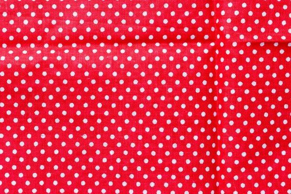 Polka dot on red canvas cotton texture. Red fabric with printed white circles. Bright colored cotton background