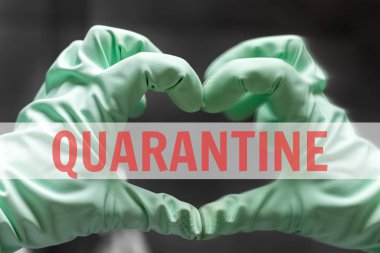 A hand in a rubber glove shows a heart sign with its reflection in the mirror against a blurred background. In the center of the photo is a white transparent stripe with a red inscription: quarantine