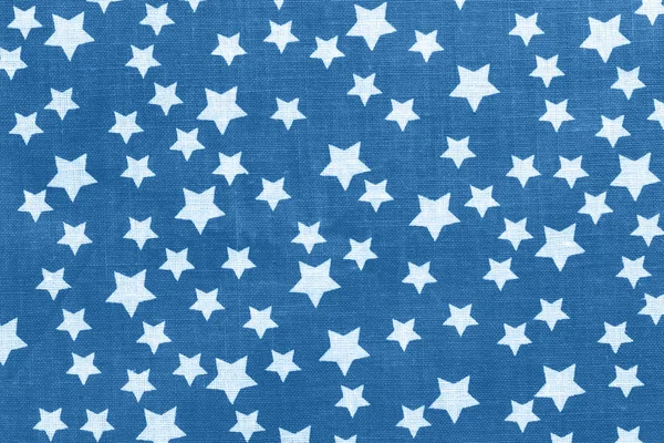 White stars on classic blue canvas cotton texture. Bright colored fabric background