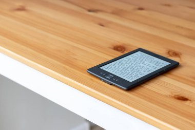 KYIV, UKRAINE - 9 Şubat 2020: ahşap bir masanın üzerindeki Amazon Kindle elektronik kitabı. Seçici odak