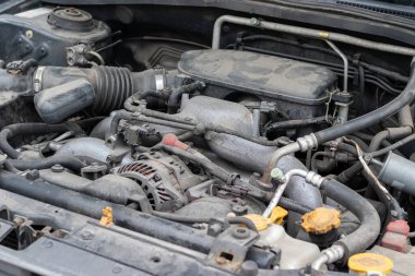 Açık kaputun altındaki dört silindirli motor kompartımanının tozlu detayları. Seçici odak