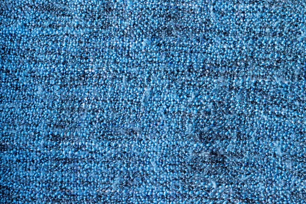 Bright blue knitted fabric texture. Rough blanket background. Closeup view