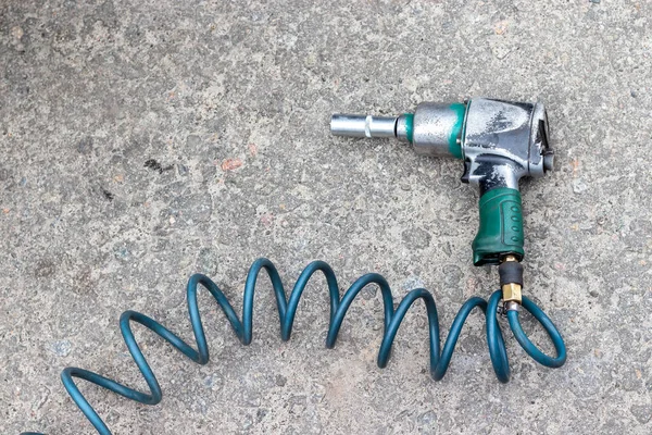 Pneumatic Wrench Green Hose Stone Paved Floor Closeup Top View — Stock Photo, Image