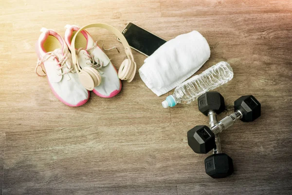 Sport equipment. Sneakers, water, towel, earphones and phone