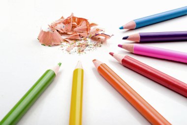 Beyaz arkaplanda renk kalemleri talaşı