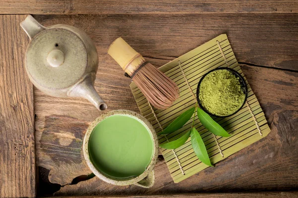 Matcha ince toz yeşil çay ahşap arka plan üzerinde.