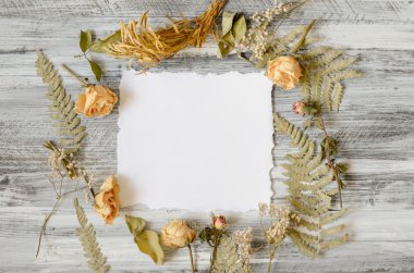 Çerçeve fern ile gül yaprakları ve dalları üzerinde ahşap arka plan