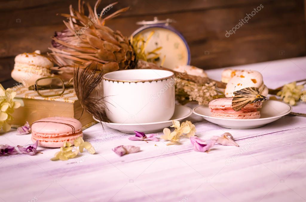 Cup of coffee with macaroons, dried flowers protea