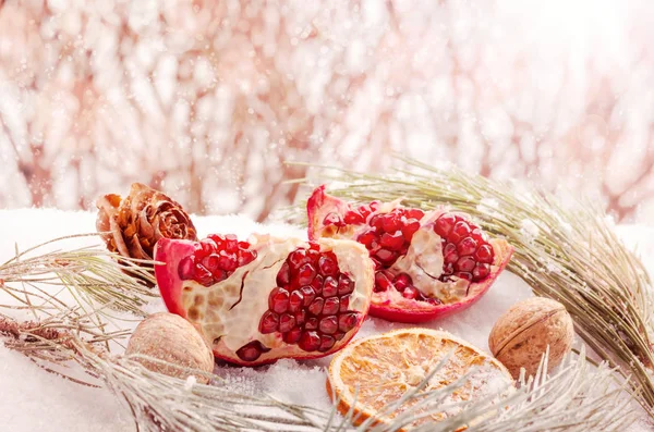 Winter scene with pomegranate, cones, branch of pine and orange — Stock Photo, Image