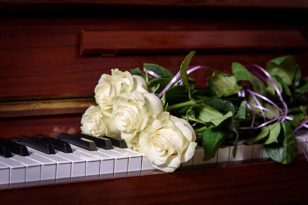 Букет цветов на клавишах пианино. Букет роз на музыкальном инструменте
.
