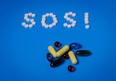 Mavi arka planda ilaç ve kapsüller var. Bağımlılık ve önleme kavramı