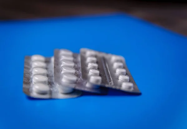 The blister packs are folded. Pills in a blister pack on a blue background.