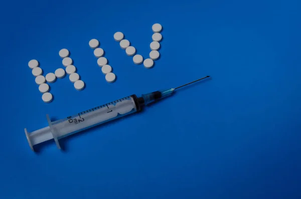 Mavi arka plandaki haplardan şırınga ve Hiv. Bağımlılık kavramı ve HIV önleme