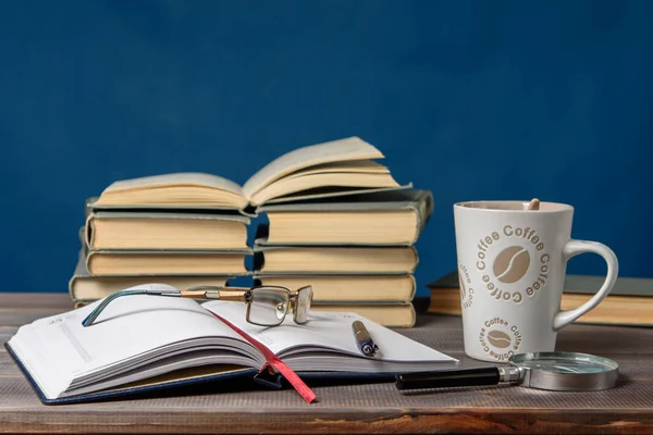 Defteri, bardakları, kalemleri, kitapları ve bir fincan kahveyi aç. Dersler için hazırlama.