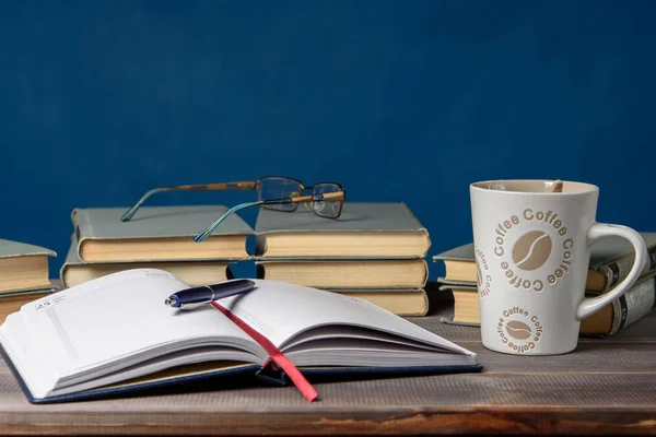 Defteri, bardakları, kalemleri, kitapları ve bir fincan kahveyi aç. Dersler için hazırlama.