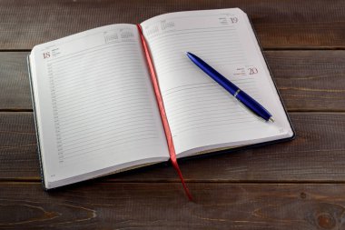 Kalem ve kitaplarla dolu bir defter aç. Üniversite sınavı hazırlık konsepti.
