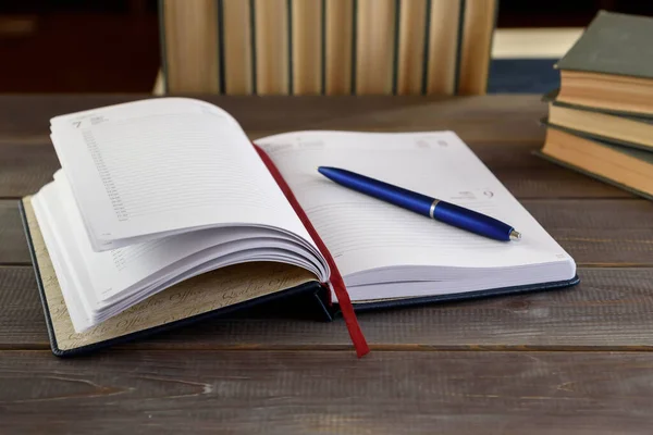 木製のテーブルの上にペンと本でノートブックを開きます 大学試験準備概念 — ストック写真