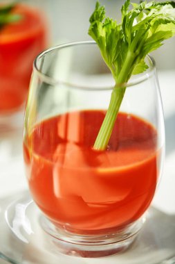 Kereviz ve maydanozlu beyaz bir tabakta domates suyu. Sağlıklı yeme kavramı