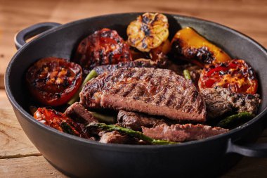 Fırında sebzeli ızgara biftek. Domates, kuşkonmaz, sarımsak ve biber.