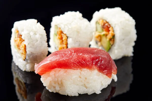 Sushi og nigiri med solomon på svart bakgrunn med refleksjon – stockfoto