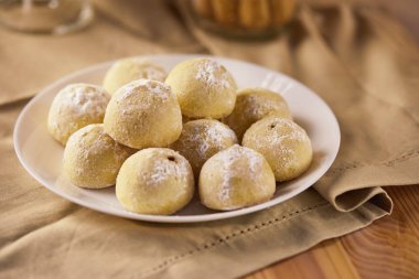 Tabaktaki ve kavanozdaki peçetedeki bej tonlu üç çeşit kurabiye. Köy tarzı kavramı.