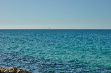 Akdeniz 'de, güneşli bir Kasım gününde taşlara, yatlara ve teknelere vuran dalgalarla