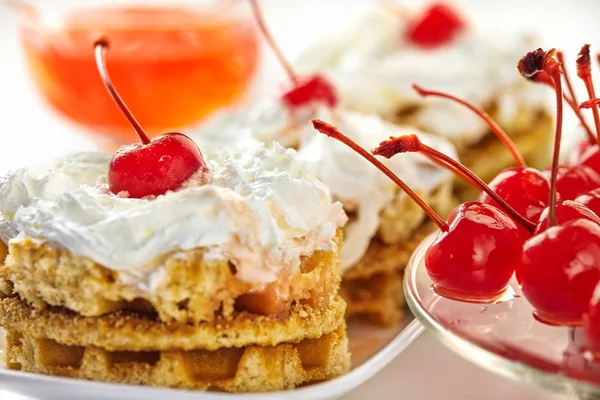 Торты со взбитыми сливками и вишнями в сахаре, на светлом фоне и вишни с сиропом — стоковое фото