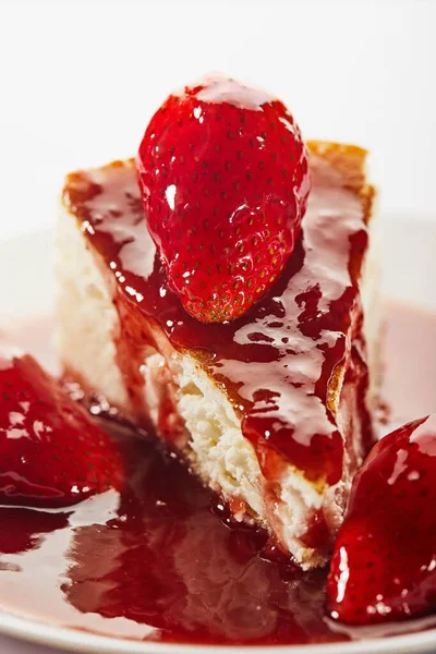 Cheesecake cu gem de căpșuni pe o placă albă pe un fundal deschis — Fotografie, imagine de stoc