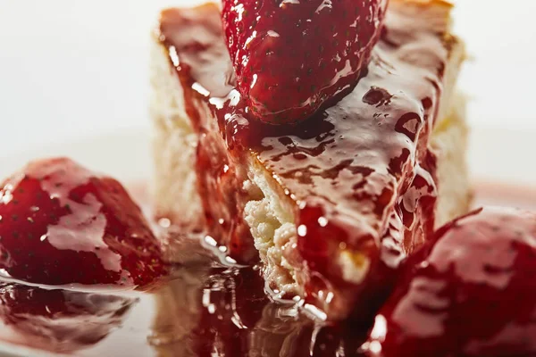 Käsekuchen mit Erdbeermarmelade auf weißem Teller auf hellem Hintergrund — Stockfoto