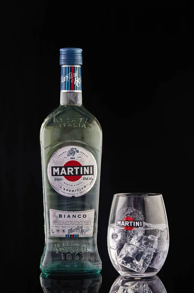 Martini şişesi ve buzlu martini bardağı. Siyah bir arka planda yansıması var..