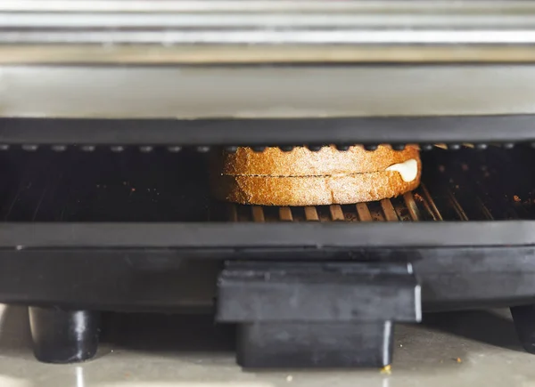 Toast of two slices of bread and cheese toasted in a toaster, close up — Stock Photo, Image