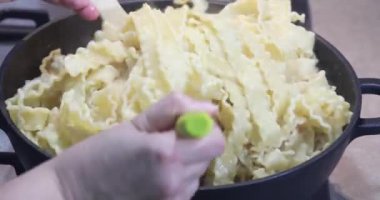Kadın, tavada kızarmış karidesli İtalyan makarnası pişiriyor..