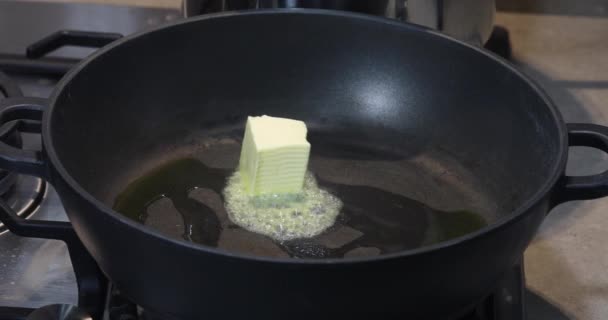 女性がバターのキューブを入れて それが溶融し 流れ熱いフライパン — ストック動画