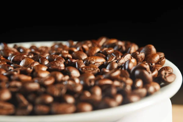 黒を基調としたホワイトプレートに香り豊かな天然コーヒーの粒。 — ストック写真