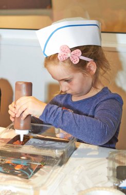 Küçük sarışın bir kızın el yapımı çikolatası, küçük bir pasta aşçısı.