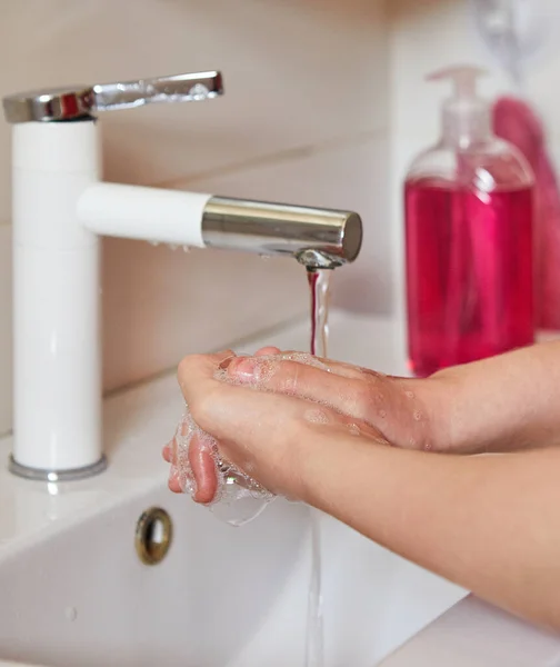 Teen girl washes hands with soap in the sink. Protect against viruses and bacteria Concept. Covid-19 or Coronas Virus.