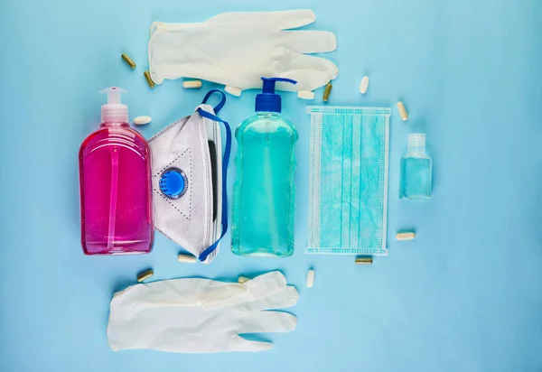 .The concept of the outbreak of coronavirus COVID-19, How to protect yourself from infection. Wash hands, wear face shield, gel, protective gloves. Copy space. Flat lay on a blue background.