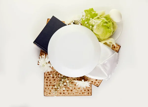 Pesah kutlaması konsepti - Yahudi bayramı Matzah arka planı ve Hamursuz Bayramı tabağı, yumurta ve marul beyaz arka planda. Uzayı kopyala Yukarıdan bak. Düz yatıyordu