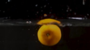 Mandarin bir su sıçramasıyla suya düşer. Yavaş çekim.