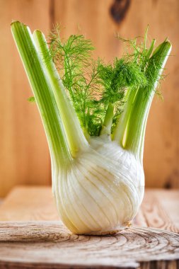 Ahşap arka planda taze organik rezene ampulü..