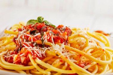 Lezzetli iştah açıcı klasik İtalyan spagettisi domates soslu, parmesanlı ve fesleğenli hafif ahşap arka planda. Yan görüş. Uzayı yakın plan kopyala