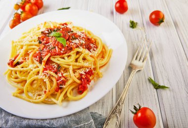 Lezzetli iştah açıcı klasik İtalyan spagettisi domates soslu, parmesanlı ve fesleğenli hafif ahşap arka planda. Yan görüş. Uzayı yakın plan kopyala