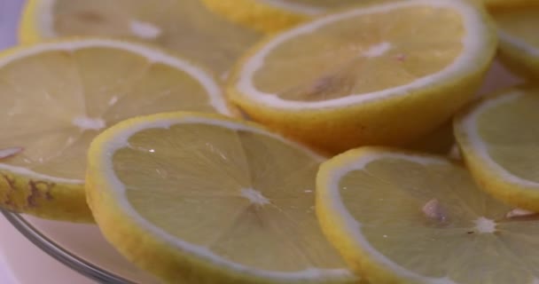 Οι φέτες λεμονιού περιστρέφονται σε ένα διαφανές πιάτο. Βίντεο 4k — Αρχείο Βίντεο