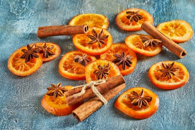 Mavi bir zemin üzerinde anason ve tarçınlı kurutulmuş portakal ya da mandalina dilimleri. Vejetaryenlik ve sağlıklı beslenme.