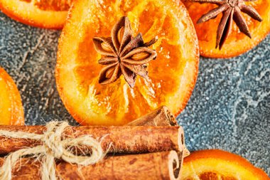 Mavi bir zemin üzerinde anason ve tarçınlı kurutulmuş portakal ya da mandalina dilimleri. Vejetaryenlik ve sağlıklı beslenme.