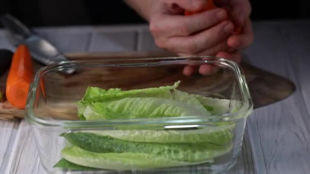 Man Throws Carrot Slices Transparent Bowl Lettuce Slow Motion — Stock Video