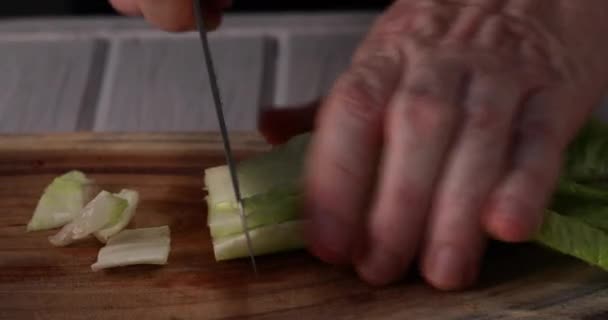 Hombre Corta Lechuga Rodajas Sobre Fondo Madera Vídeo — Vídeo de stock