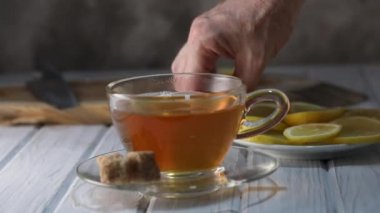 Limon dilimi yavaş çekimde bir fincan sıcak çaya düşer..