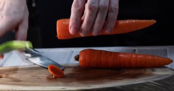 一个人把胡萝卜剥落在木制的背景上 4K视频 — 图库视频影像
