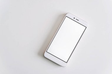 Beyaz cep telefonu modeli yüzeyde beyaz arka planda izole edilmiş, web projeniz veya tasarım sunum teknolojileriniz için kullanılabilir boş ekran ile yatar